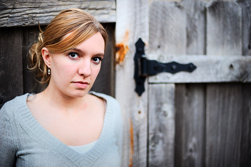 Photograph of Colleen, senior style, against fence